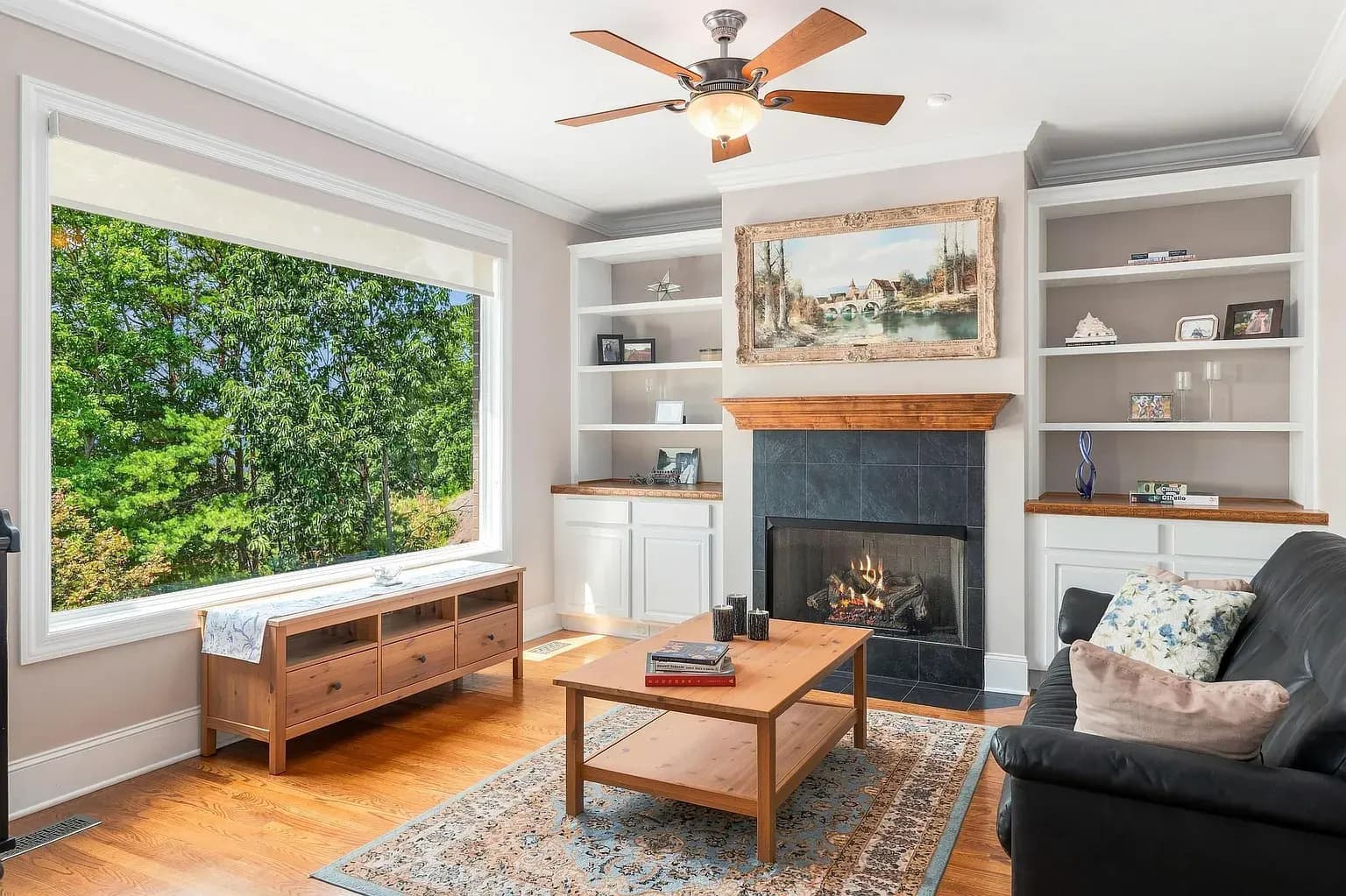 A bright living room with a fireplace, wood floors, and seating ready to enjoy.