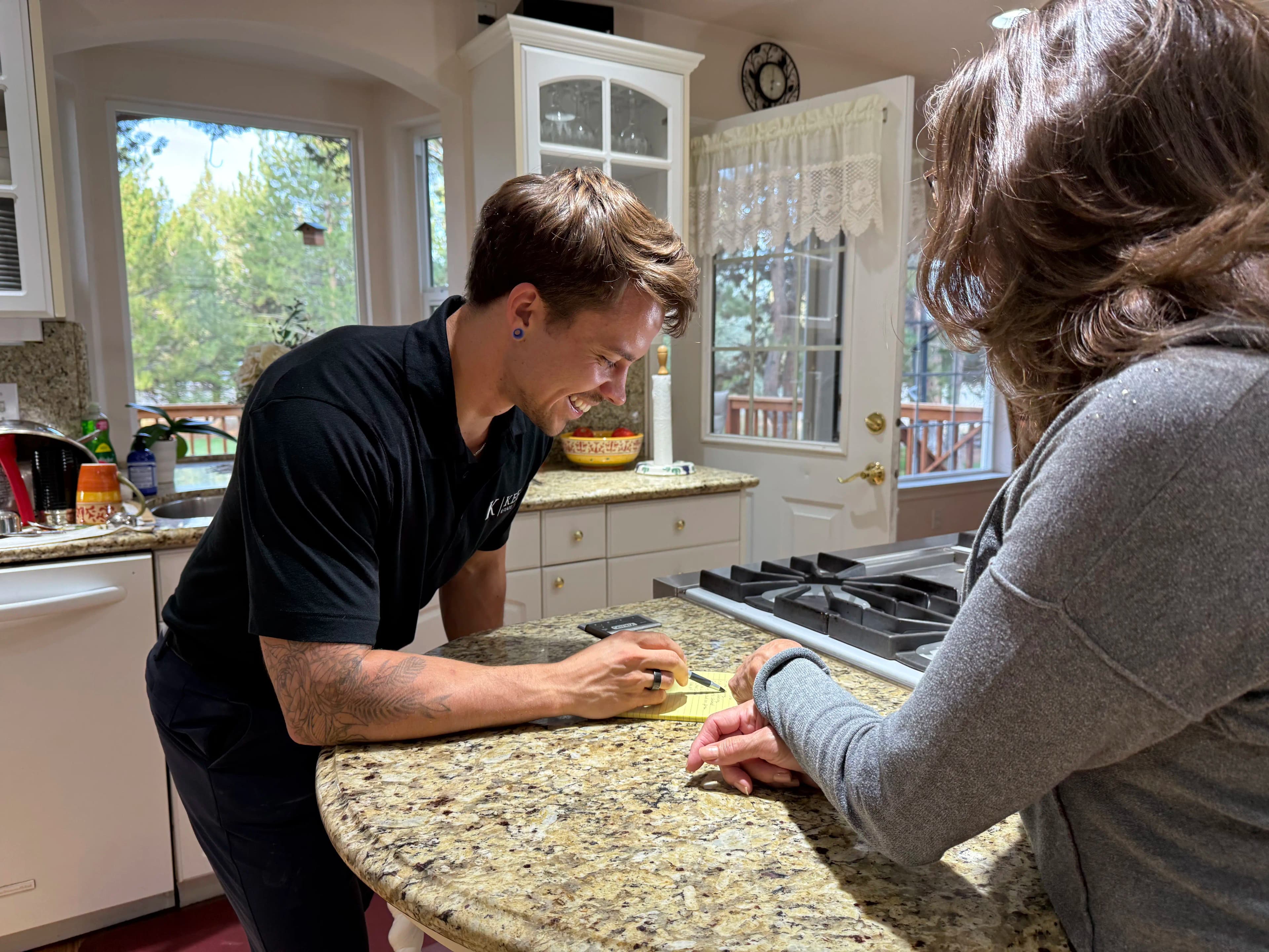 A Keep team member reviewing a handwritten house list with a homeowner.