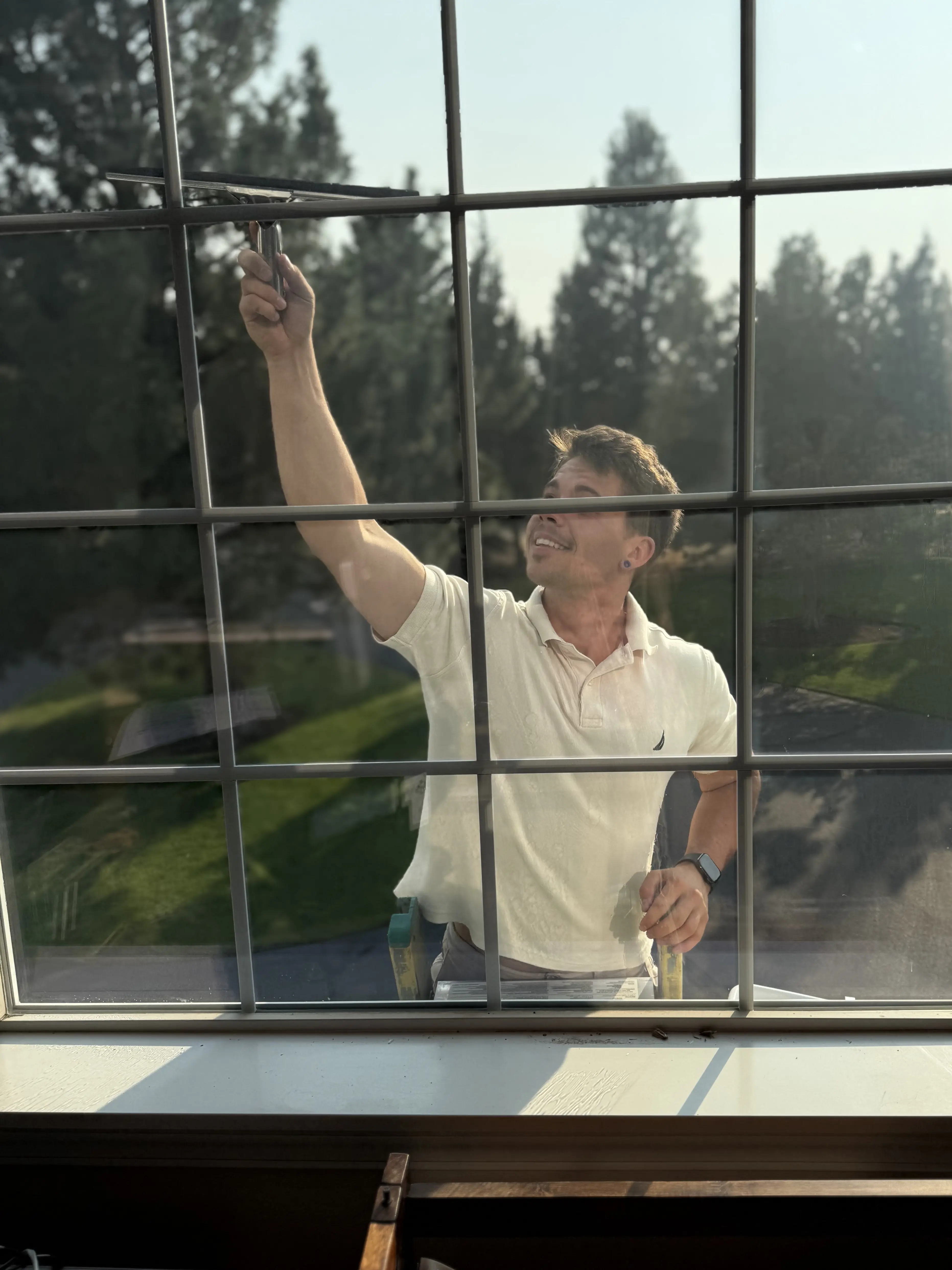 Window cleaning with a squeegee, seen from inside the home.